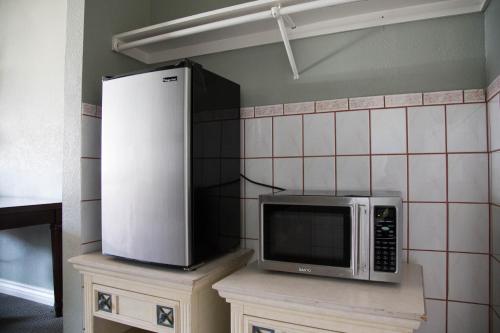 a microwave sitting on top of a counter in a kitchen at Sahara Motel in Anaheim