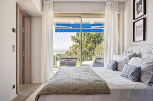 a bedroom with a large bed and a large window at Riviera luxury estates in Antibes