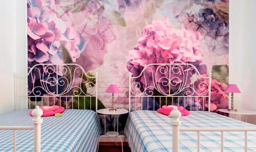 a bedroom with two beds and a mural of flowers at Caza Latina in Lisbon