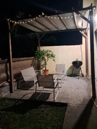 a group of chairs under a pergola with lights at o coin la sominé in Saint-Leu