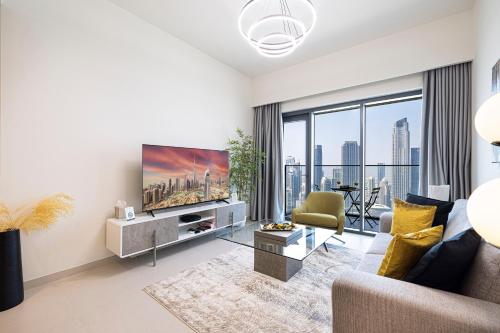a living room with a couch and a tv at SmartStay at Burj Royale - Full Burj Khalifa View - Brand New Luxury Apartments in Dubai