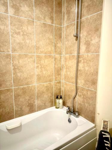 a bath tub in a bathroom with a shower at Peaceful park side apartment in Hastings