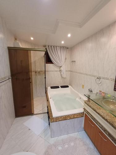 a bathroom with a bath tub and a sink at Casa inteira 3 quartos Centro em Pomerode in Pomerode