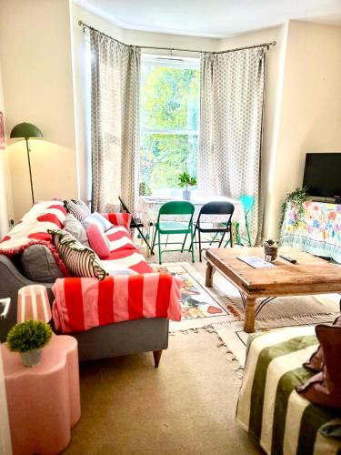 a living room with a couch and a table at Peaceful park side apartment in Hastings