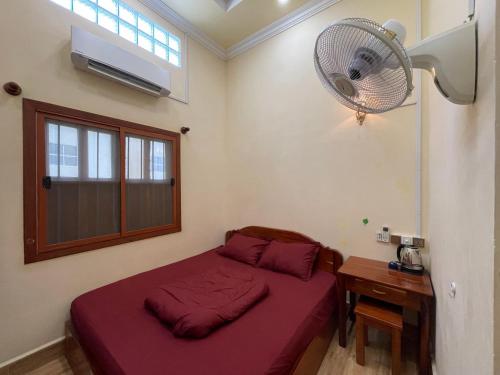 a bedroom with a bed with a fan and a desk at Homestay342 in Phumĭ Svay Chh'êh