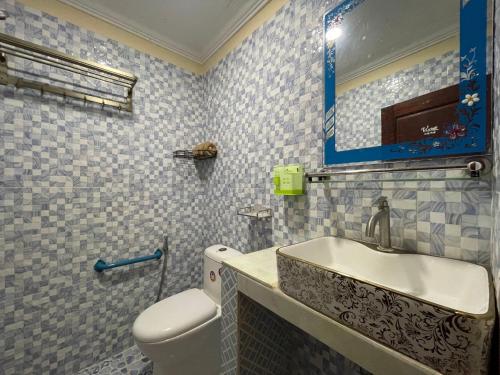 a bathroom with a sink and a toilet and a mirror at Homestay342 in Phumĭ Svay Chh'êh