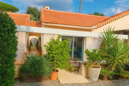 a house with plants in pots in front of it at Rêve D'azur plage de la Nartelle studio 20m2 avec piscine partagée, parking Barbecue, draps inclus à la Nartelle in Sainte-Maxime