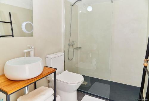 a bathroom with a white toilet and a shower at Casa Codol in Illes Balears