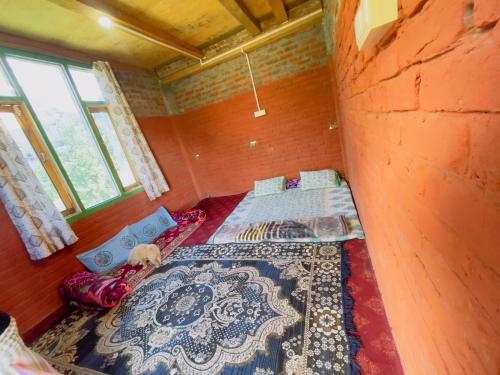 a room with two beds and a wall with windows at MJ cafe and homestay in Kalgha