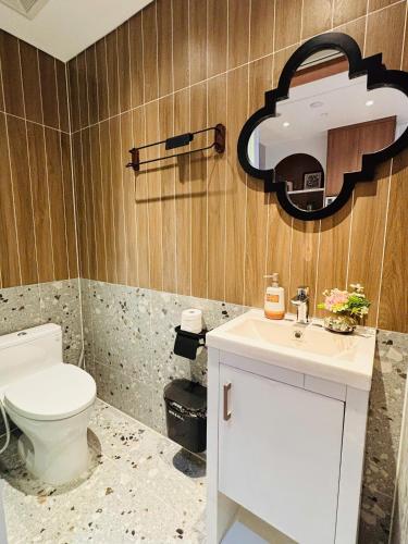 a bathroom with a toilet and a sink and a mirror at Ecopark Duplex Homestay by QMP in HÆ°ng YÃªn