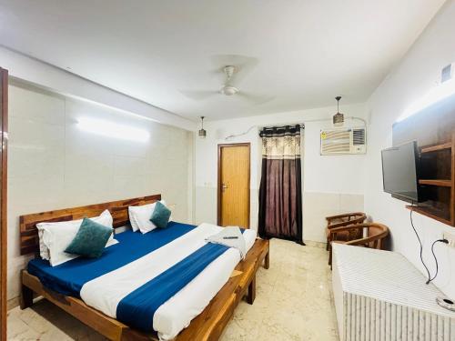 una camera da letto con un letto grande e una televisione di Hotel Royal Valley 10 Mins Away From Nizamuddin Railway Station a Nuova Delhi