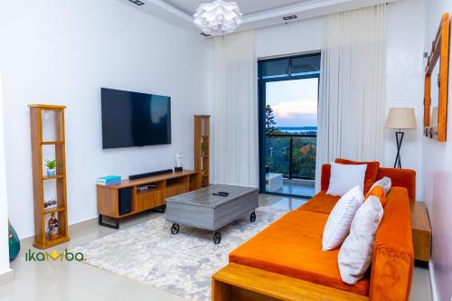 a living room with a couch and a flat screen tv at Ikamba-Lakeview Apartment in Kampala