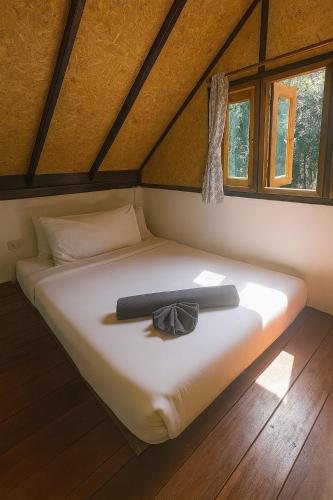 a bed in a room with a bow tie on it at Anattaya Holiday Home in Ko Yao Noi