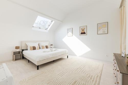 a white bedroom with a bed and a staircase at Villa Fantasia - 10 min Disneyland - 8 people in Coupvray
