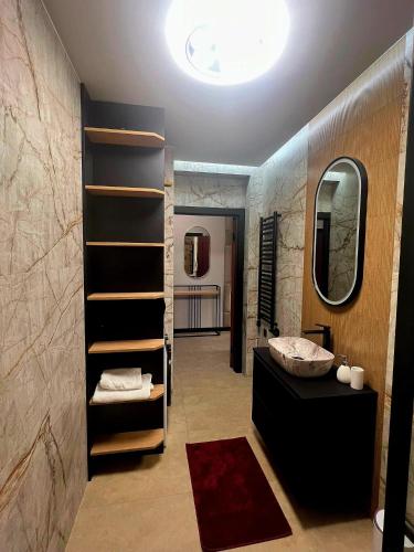 a bathroom with a sink and a mirror and a shelf at ZIBO APARTMENTS LESKO Nowoczesne apartamenty z jacuzzi i widokiem na Bieszczady in Lesko