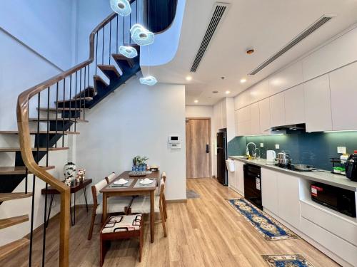 a kitchen and dining room with a spiral staircase at Ecopark Duplex Homestay by QMP in HÆ°ng YÃªn