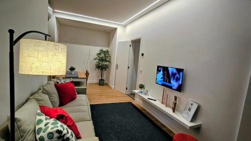 a living room with a couch and a flat screen tv at ElevenPlace by LouzanPlaces in Lousã