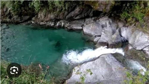 a river with water coming out of the rocks at Hotel Victoriya Palace,Mcleod Ganj in McLeod Ganj