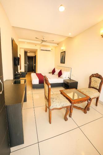 a hotel room with a bed and a table and chairs at Hotel JB Residency Zirakpur Chandigarh # Large Rooms # Balcony Rooms # Top Rated in Zirakpur
