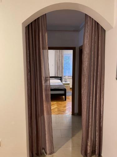 an archway in a room with a bed and a mirror at Apartment Dada in Bjelovar