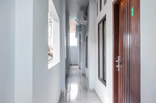 an empty hallway with a wooden door and a hallwayngth at Dancenter Z Hotel in Bandar Lampung