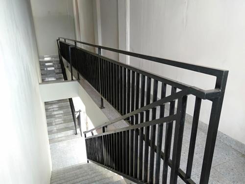 a staircase in a building with a black railing at Dancenter Z Hotel in Bandar Lampung