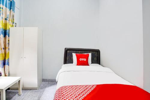 a bedroom with a red pillow on a bed at Dancenter Z Hotel in Bandar Lampung