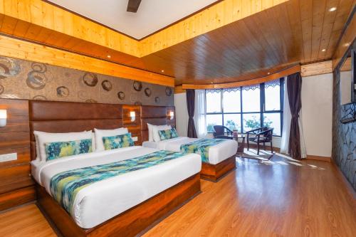 a bedroom with two beds in a room with a window at Sumitel Queens Yard in Darjeeling