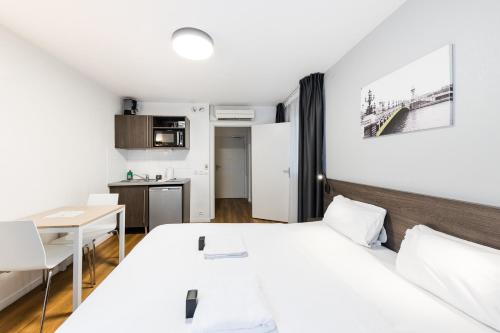 ein Schlafzimmer mit Bett und Tisch und eine Küche in der Unterkunft Cozy Marne - 2 people - Paris in Nogent-sur-Marne