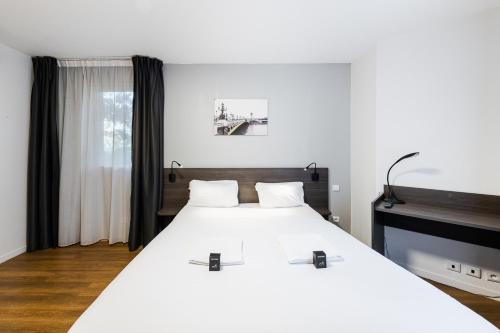 ein Schlafzimmer mit einem großen weißen Bett und einem Fenster in der Unterkunft Cozy Marne - 2 people - Paris in Nogent-sur-Marne