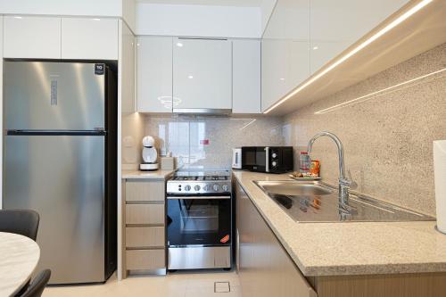 a kitchen with a stainless steel refrigerator and a sink at SmartStay at Burj Royale - Full Burj Khalifa View - Brand New Luxury Apartments in Dubai