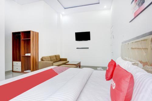 a bedroom with a bed and a couch and a television at Dancenter Griya Bawean in Tanjungkarang