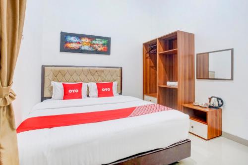 a bedroom with a large bed with red pillows at Dancenter Griya Bawean in Tanjungkarang