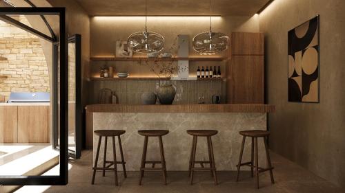 a kitchen with a bar with stools in it at 12 Islands Villas in Kolimbia
