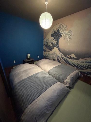 a bedroom with a large wave mural on the wall at sukeemon in Biei