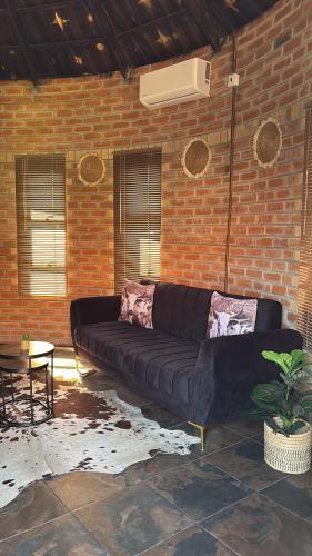 a large black couch sitting in a brick wall at Oceans Bavarian Boutique Apartments in Maun