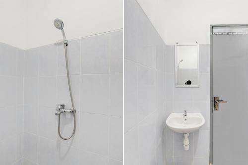 a white bathroom with a shower and a sink at Dancenter Stipram Kaliurang in Kaliurang
