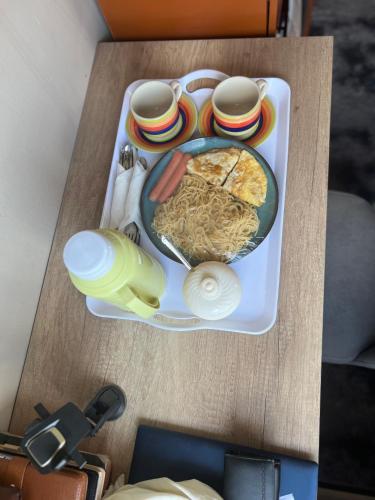 a tray of food with noodles on a table at Everlasting stays in Dar es Salaam