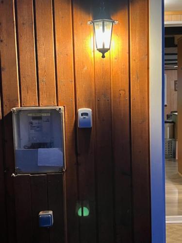 a light on a wooden wall with a light on it at Spacious Summerhouse with Hot Tub & Garden in Selfoss