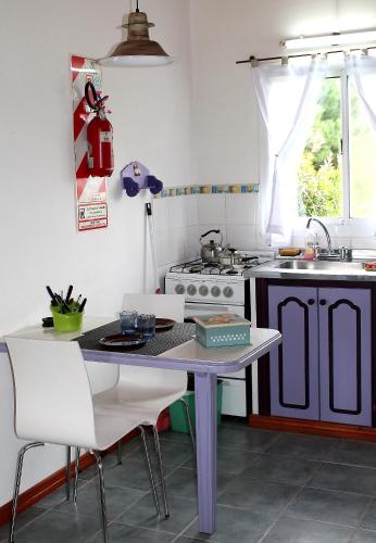a kitchen with a table and a sink and a stove at Cabañas Arcángeles de Tandil in Tandil