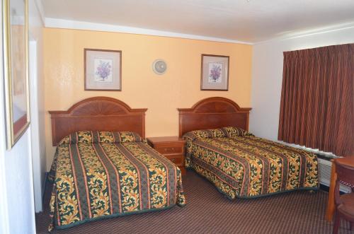 a hotel room with two beds and a table at Seaside Inn Motel in Port Hueneme