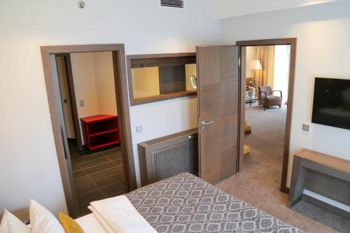 a hotel room with a bed and a tv and a room at Schlosshotel Kitzbühel in Kitzbühel