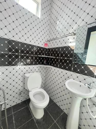 a bathroom with a white toilet and a sink at Capital O 91227 Chalet D'bendang Mak Teh in Pendang