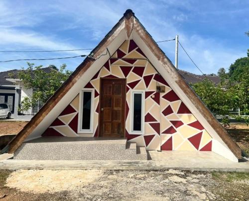 a small house with a triangular roof with a door at Capital O 91227 Chalet D'bendang Mak Teh in Pendang