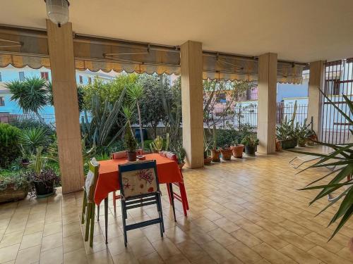 a room with a table and chairs and potted plants at Casa Letizia Appartamento Completo in Sannicola