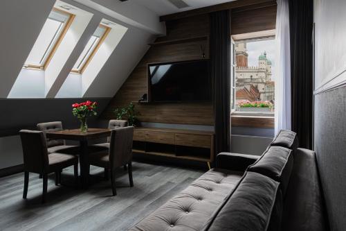 a living room with a couch and a table at RATUSZOVA Stary Rynek Old Market PREMIUM Apartments & Restaurant AD 1954 in Poznań