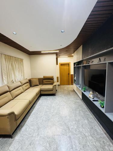 a living room with a large couch and a television at Shreshtam Apart Hotel, Kondapur in Lingampalli