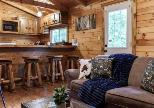 a living room with a couch and a bar at Copperhead Cabin- Hocking Hills Hot Tub Games in Logan