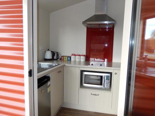 a small kitchen with a sink and a microwave at The Red Hut in Lake Tekapo