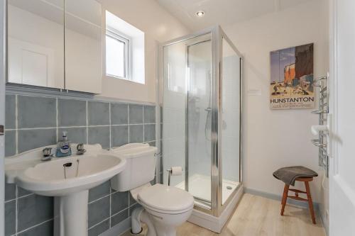 索海姆North View - Norfolk Cottage Agency的浴室里有马桶、洗手池和淋浴。